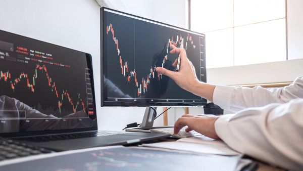 Investidora analisando detalhadamente oscilação de ações na bolsa de valores para fazer venda coberta de call