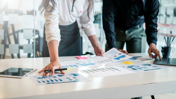 Investidores avaliando juntos dados recentes de empresa para usar ou não ativo em estratégia de opções