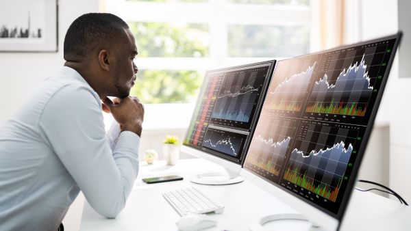 Investidor analisando desempenho de diferentes ativos na bolsa de valores antes de aplicar seu dinheiro