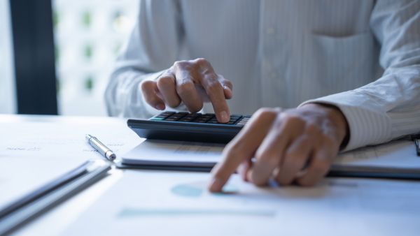 Investidor calculando depreciação de ativos da empresa antes de aplicar seu dinheiro