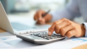 Investidor calculando saídas e entradas para fazer livro-caixa