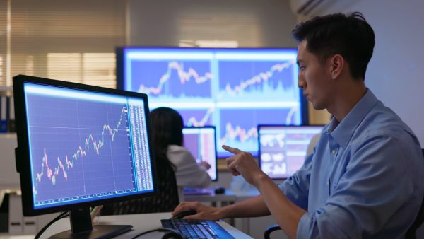 Investidores em escritório analisando desempenho de ativos que estão em seu portfólio