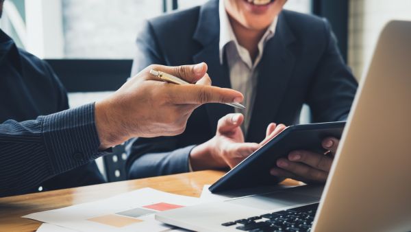 Investidores felizes ao analisar resultados de investimentos na área do investidor, antigo Cei