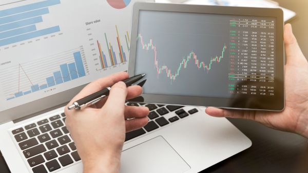 Investidor analisando movimentos de ações na B3 junto de dados da empresas mostrando praticidade de operar