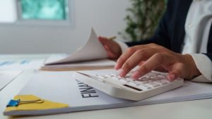 Investidor com dados de empresa e calculadora para analisar sua liquidez corrente