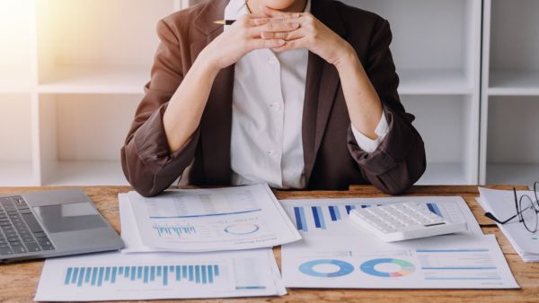 Investidora analisando balancete de verificação de empresa para validar lançamentos contábeis