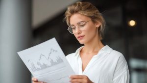 Investidora analisando últimas flutuações de ativo com ATR antes de abrir ou encerrar posições