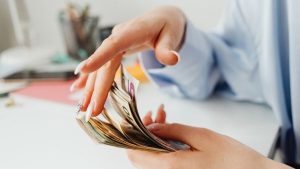 Investidora contando valor de dividendos em dólar recebidos e sacados