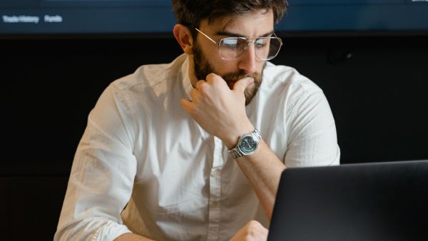 Trader acompanhando-comportamento de ativos pelo laptop antes de abrir ou fechar posições