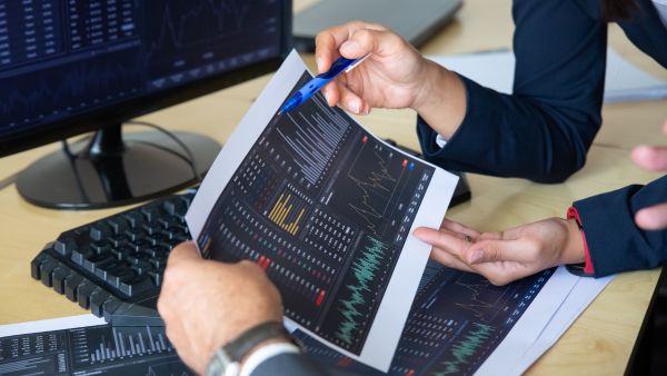 Traders discutindo estratégia para melhorar seus rendimentos ao operar