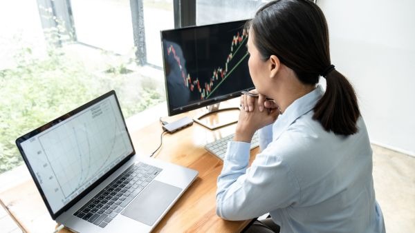 Investidora analisando comportamento anterior de ativos para abrir posições de long ou short