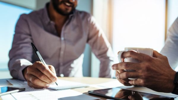 Investidores discutindo estratégias de long e short para aumentar rendimentos e proteção de carteira