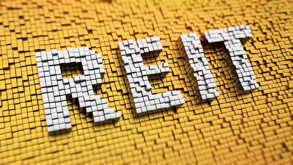 Centenas de cubos formando o nome "REIT" representando o glossário de REITs, que explica diversos termos ligados a classe de ativos