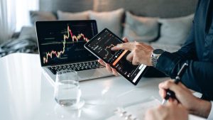 Especuladores verificando gráficos de múltiplas empresas com base em análise técnica para obter lucros rápidos com variação de preço