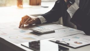 Investidor analisando múltiplos dados de empresa e calculando liquidez corrente e liquidez seca para saber capacidade do negócio em cumprir obrigações de curto prazo