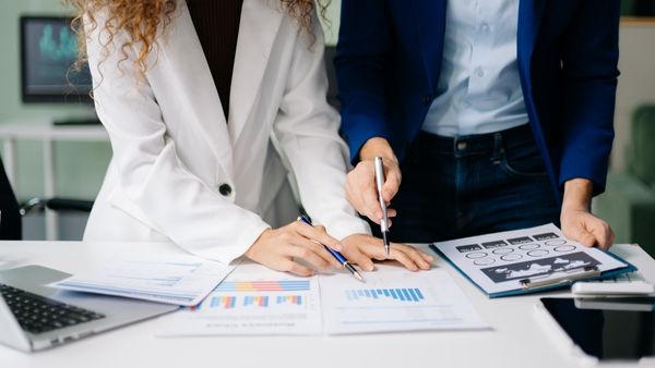 Investidores analisando juntos demonstrações financeiras de empresa em que pretendem investir