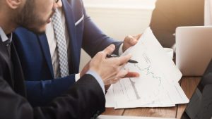 Investidores analisando notas explicativas de empresa junto com demonstrativos financeiros