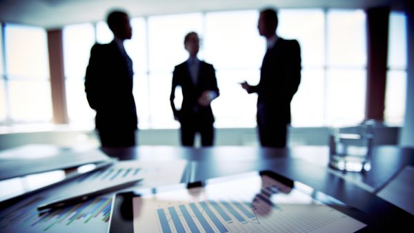 Investidores conversando após usar análise criteriosa para identificar boas ações para investir e adicioná-las na carteira