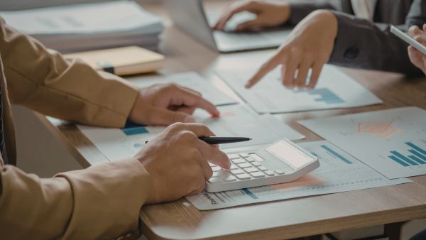 Investidores utilizando dados de empresa e indicadores fundamentalistas para encontrar melhores ações para investir