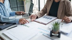 Gestores discutindo estratégia da empresa utilizando contabilidade gerencial como uma das referências