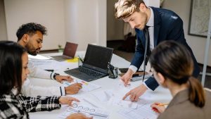 Investidores analisando juntos demonstrações financeiras e projeções do guidance divulgados por empresa