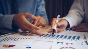 Investidores analisando juntos DRE de empresa referente ao último período