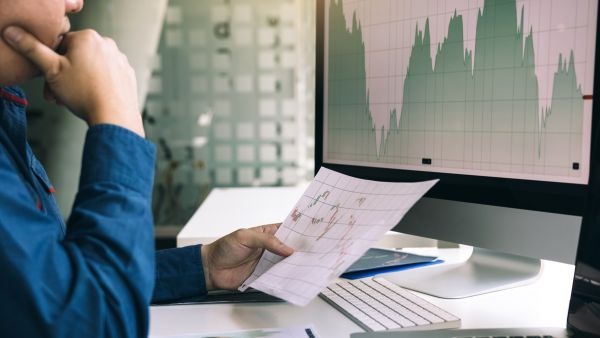 Investidor acompanhando variação de preços de ativos para aplicar seu  dinheiro nas melhores empresas do momento