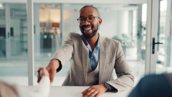 Investidor feliz falando com outros investidores sobre seus resultados investindo em ativos no OTC