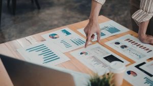 Investidora analisando múltiplos dados de empresa incluindo o capital circulante líquido para avaliar sua capacidade de pagamento no curto prazo