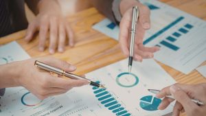 Investidores avaliando juntos contas de resultado da empresa na DRE