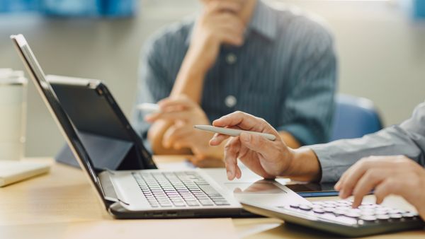 Investidores discutindo se vale a pena investir em ativo com restrição de venda temporária